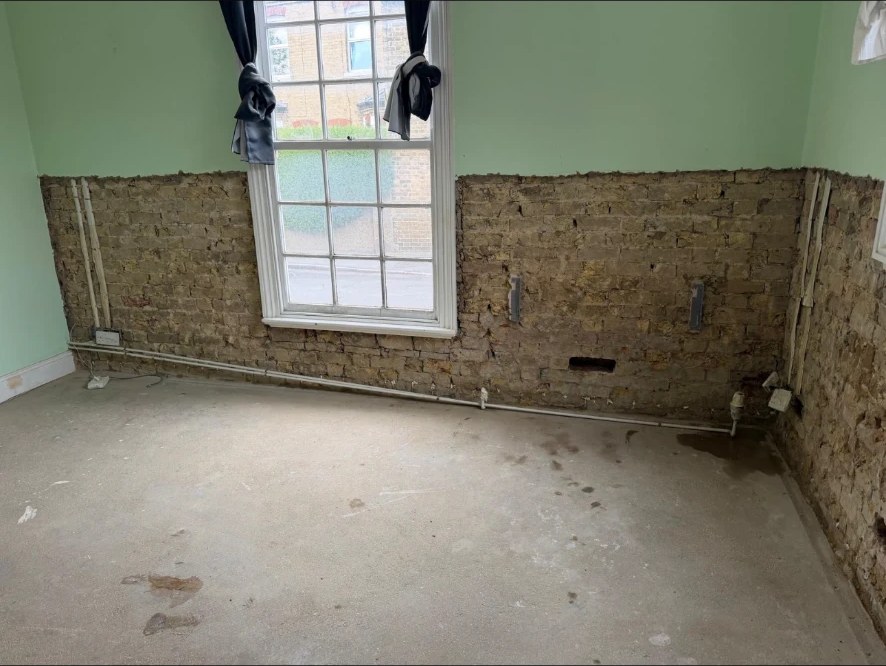 Back to brick — Contaminated plaster removed to 1m and salt-laden render taken off ready for treatment.