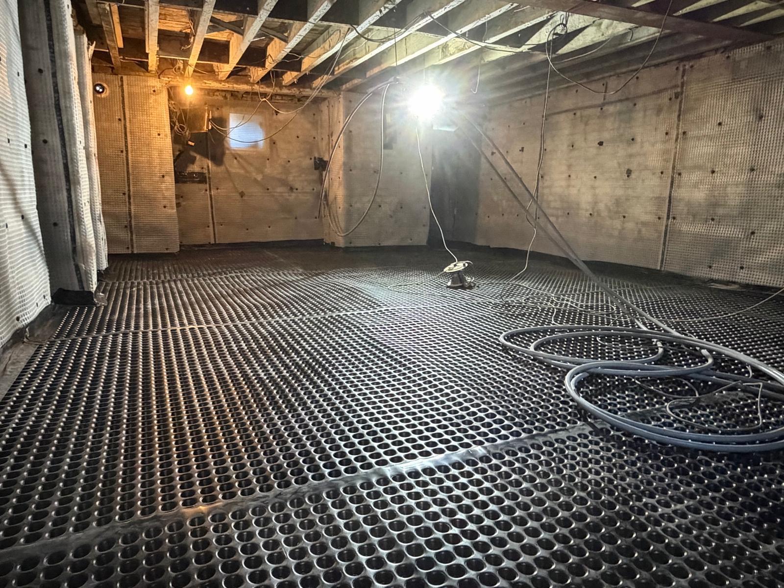 Wall-to-floor protection — Continuous waterproofing fitted around the room, including columns and difficult junctions.