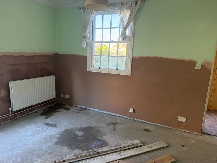Bedroom wall freshly re-plastered after rising damp treatment